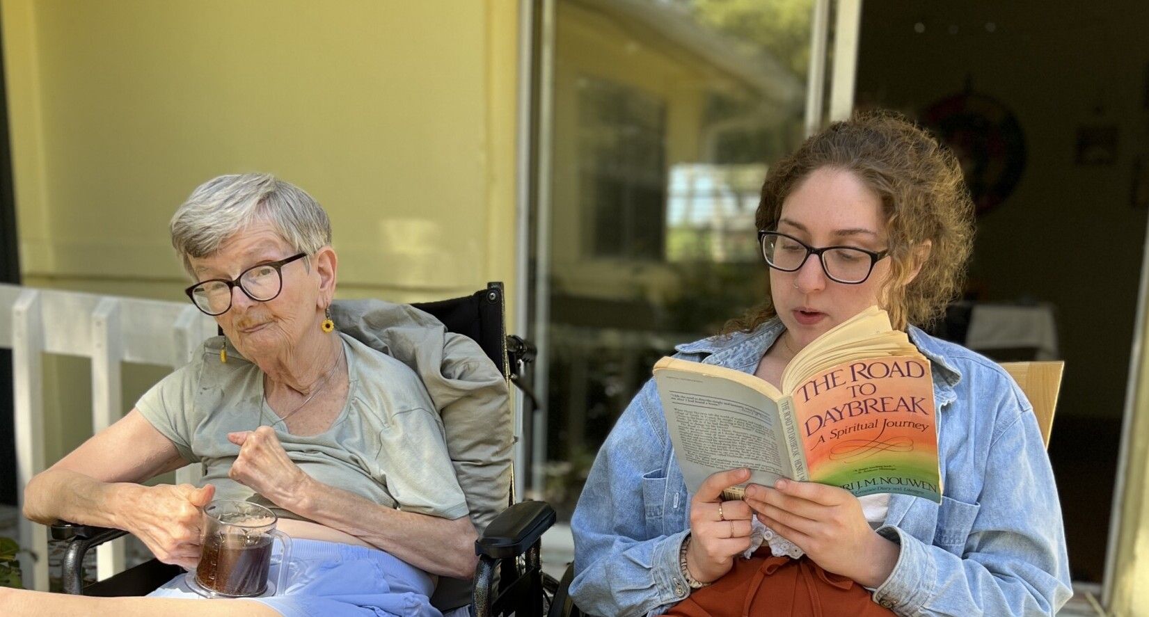 Assistant and Core member reading Henri Nouwen outside